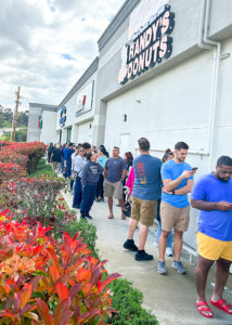Customers wait in long line around the building at Randy's Donuts in San Diego