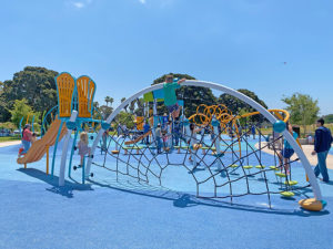 Child climbing on spider web climbing structure at Tecolote Shores in Mission Bay park.