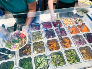 Fresh and healthy salad topping options at Sweetgreen Del Mar includnig cucumber, avocado, broccolio, sweet potato, and purple cabbage. 