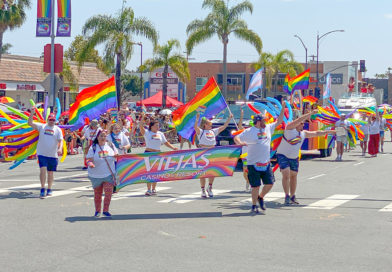 San Diego Pride 2023 Viejas float and parade marchers with rainbow flags.